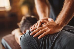 Person gently stretching beside a window after experiencing mild back discomfort at home